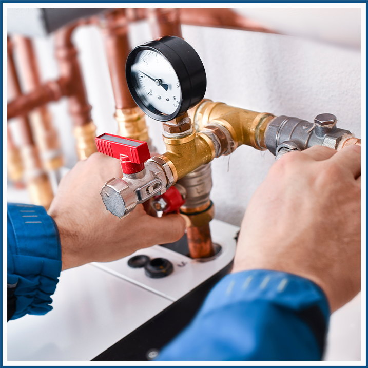 Hands on well-pump valves and a pressure gauge